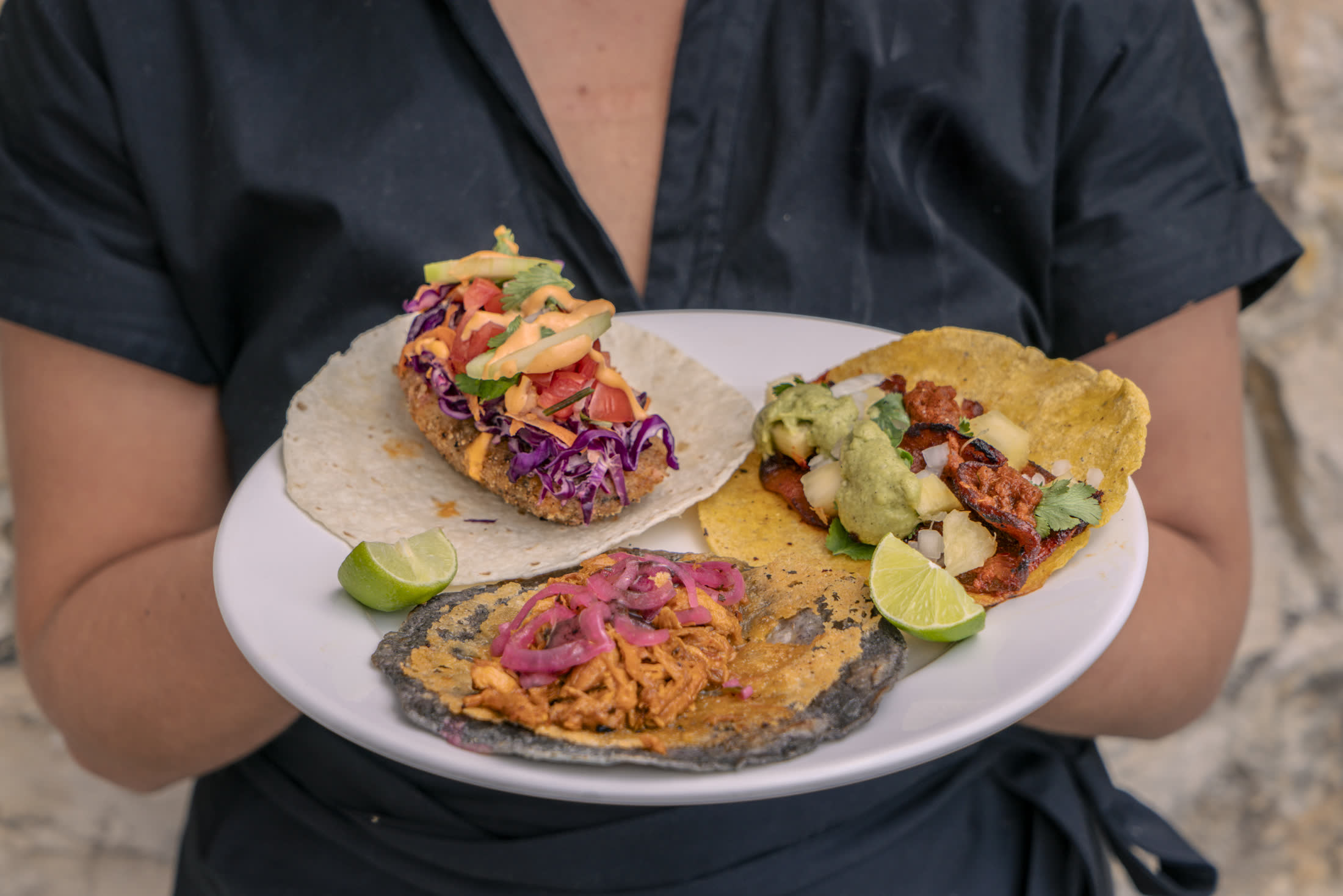 A plate of three tacos being served